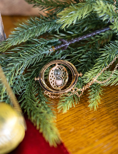 Mise en scène sur des branches de sapin du collier retourneur du temps