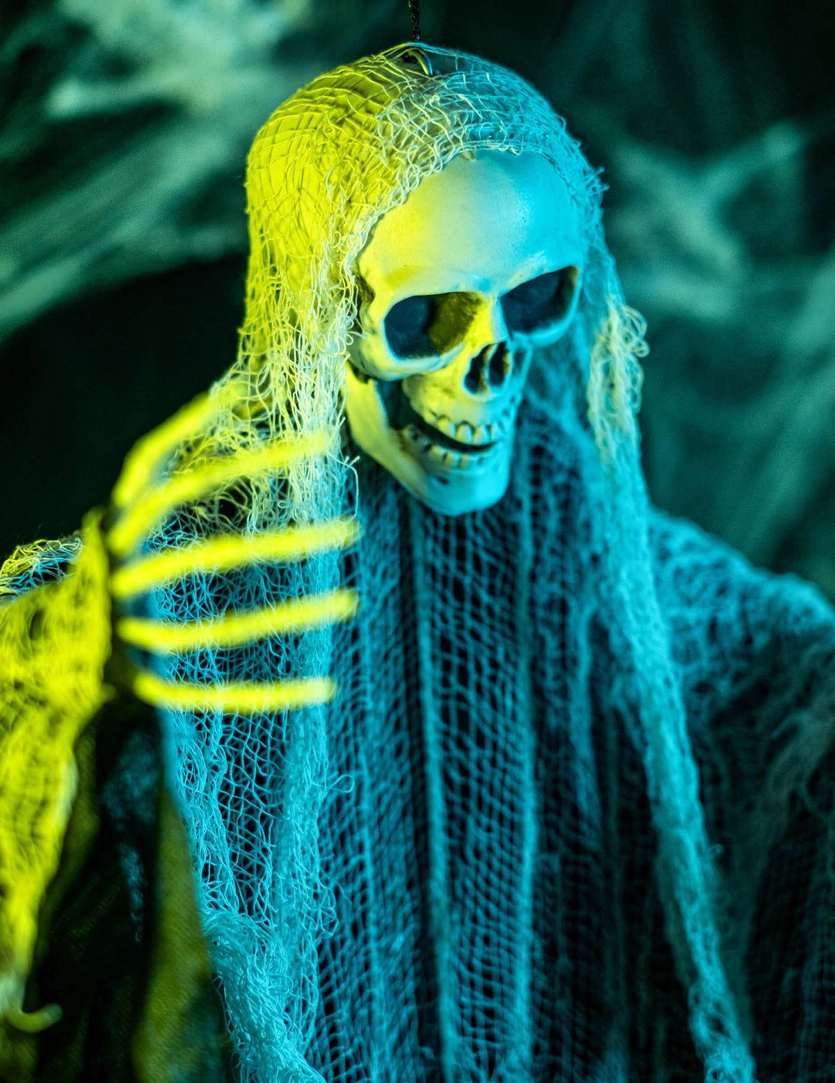 Közelkép a halloween-i kaszás dekoráció csontvázkezéről