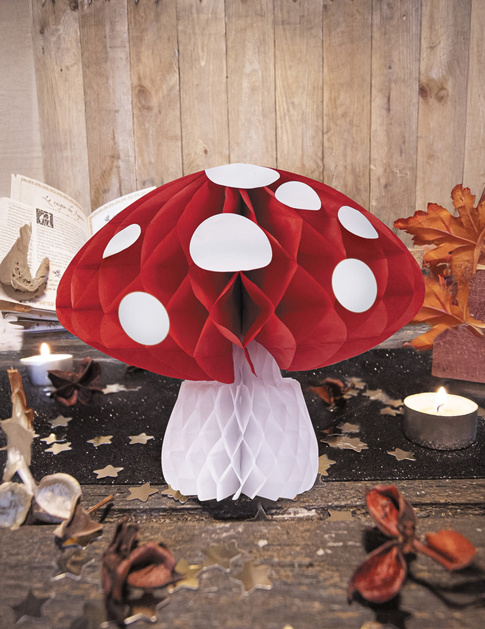 Mise en scène avec bougies de la décoration champignon alvéolé pour fête rouge et blanc