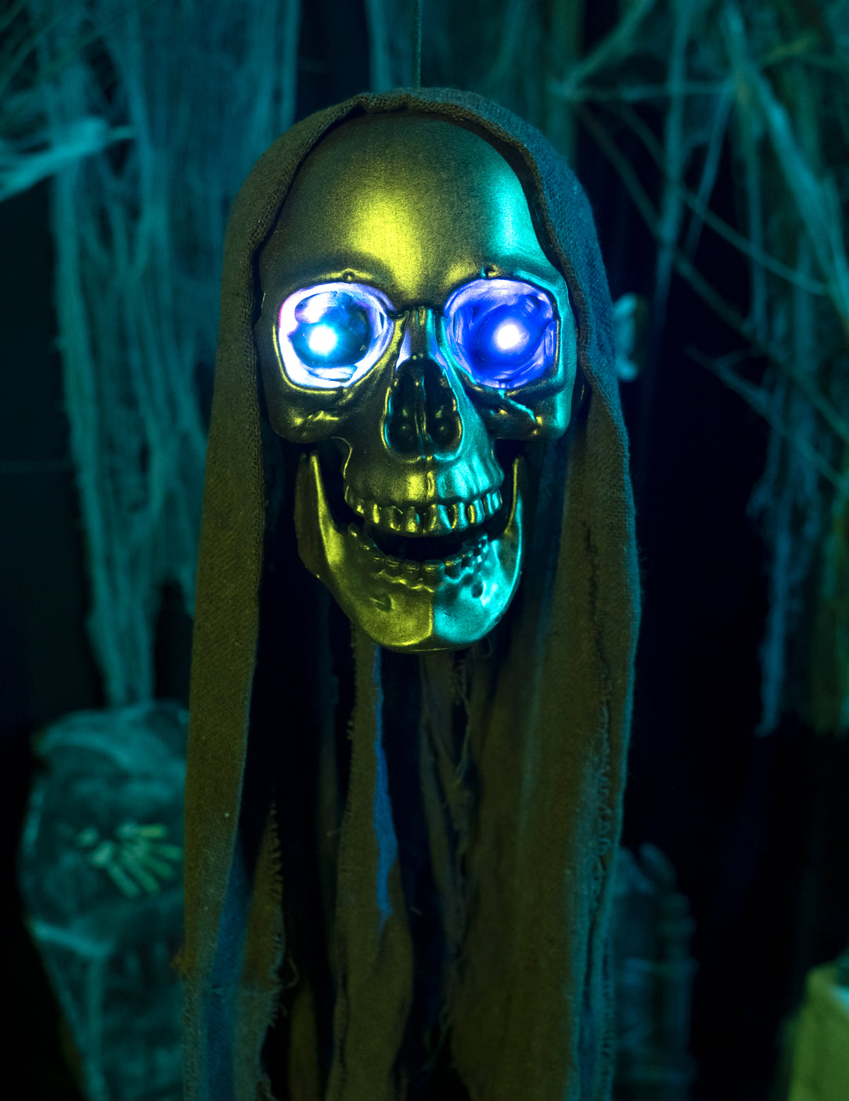 Gros plan sur les yeux bleus lumineux de la décoration tête de faucheuse à suspendre Halloween