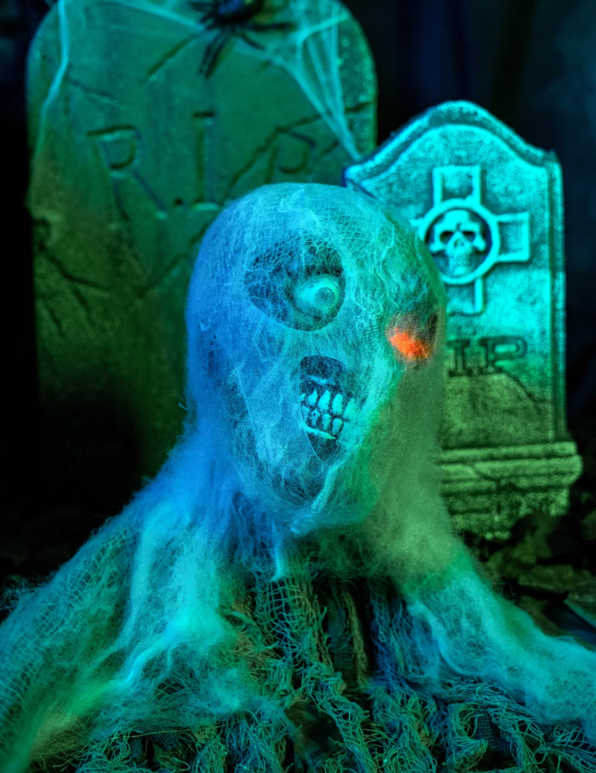 Nagyítás az animált halloween-i zombik dekorációjának pókhálóval borított arcára