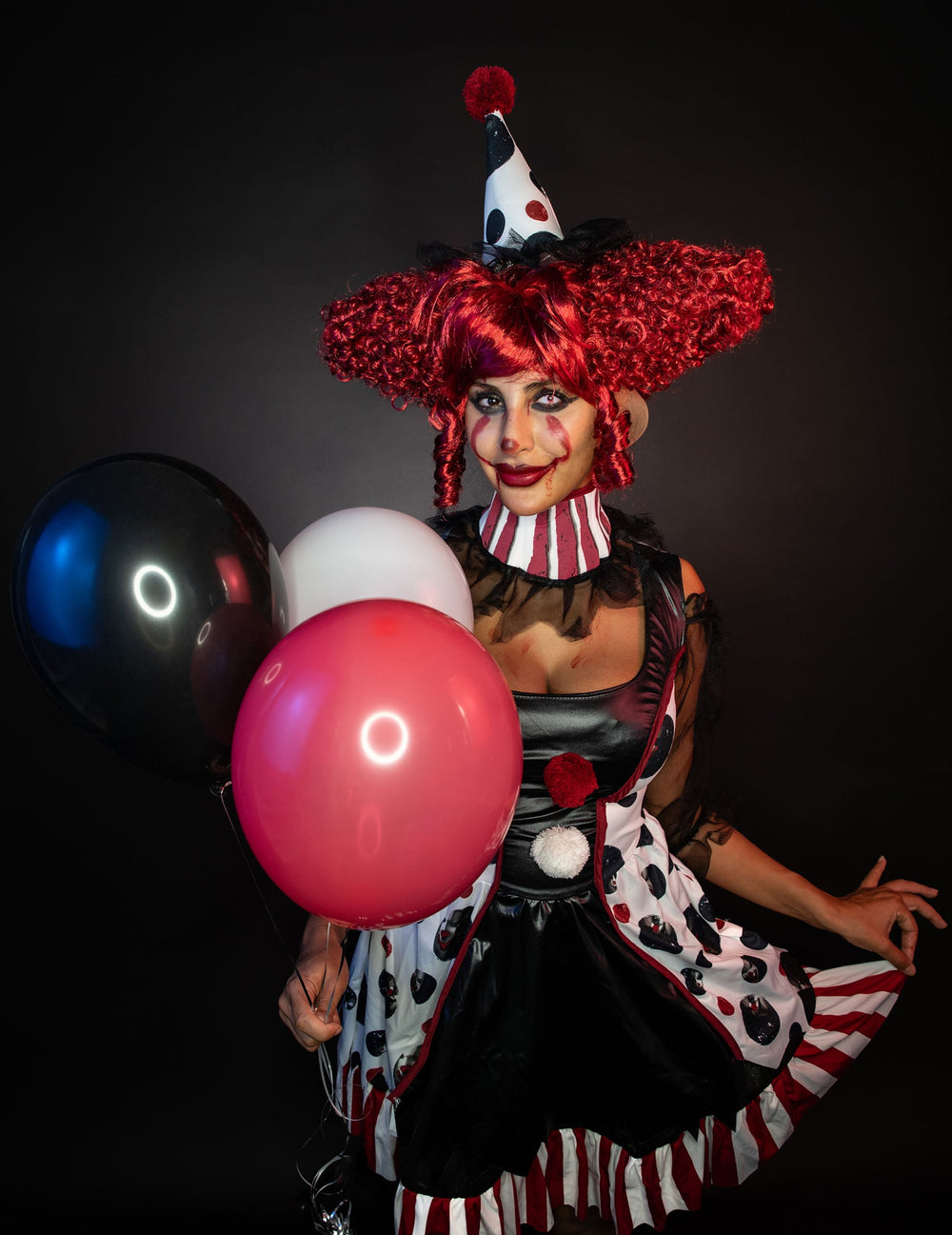 Vue de face avec ballons du déguisement de clown psycho pour femme