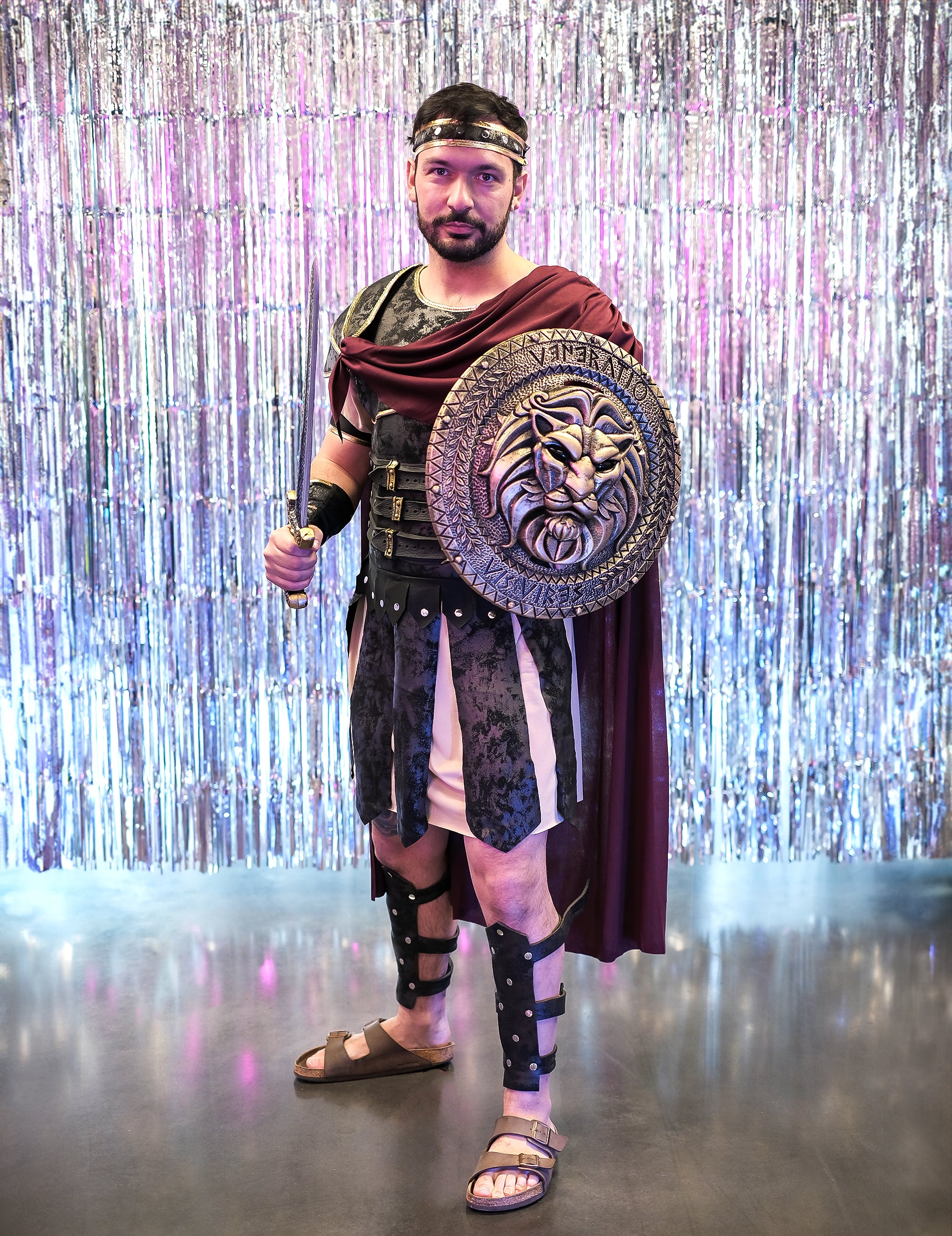 Mise en situation sur fond argenté brillant du déguisement de gladiateur romain pour homme