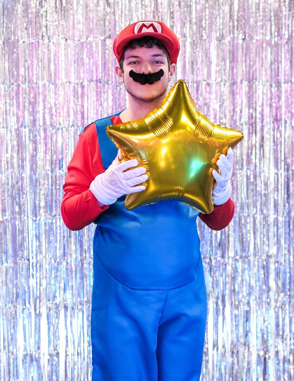 Beállított jelenet egy arany csillag alakú lufival felnőtt Mario jelmezhez