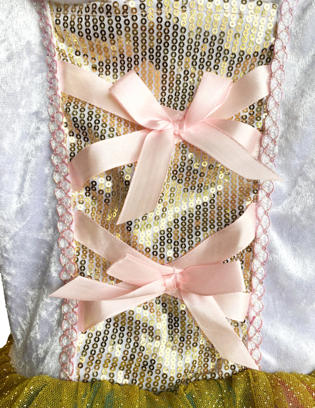 Détail du bustier à sequins dorés et nœuds roses du déguisement Princesse Licorne lumineuse