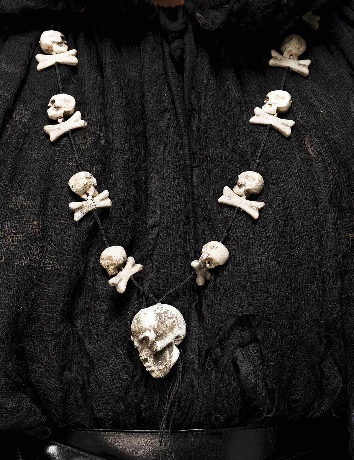 Détail du collier avec têtes de mort et os du déguisement sorcier occulte avec masque luxe