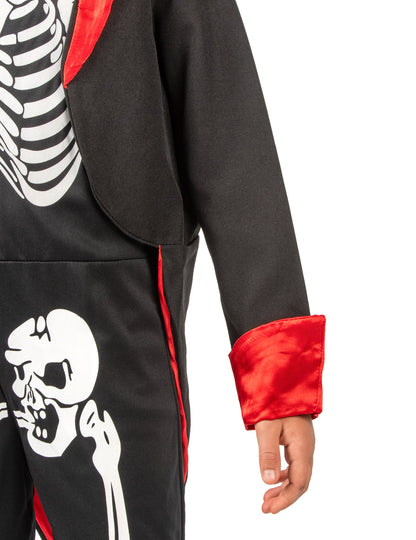 Détail du revers de manche rouge et de l'imprimé du déguisement squelette chic pour garçon