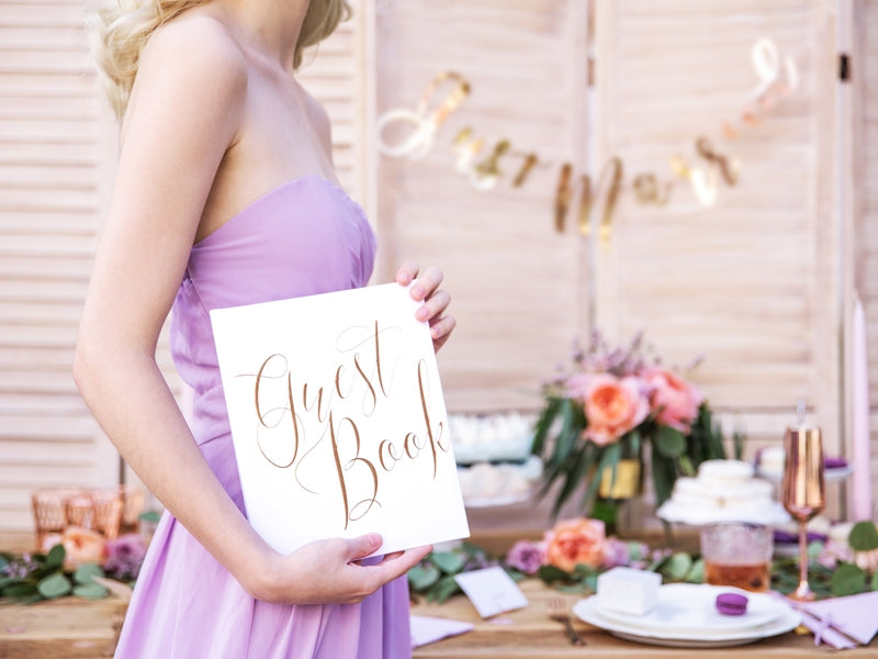 Mise en situation tenue à la main du guest book pour mariage blanc et rose gold