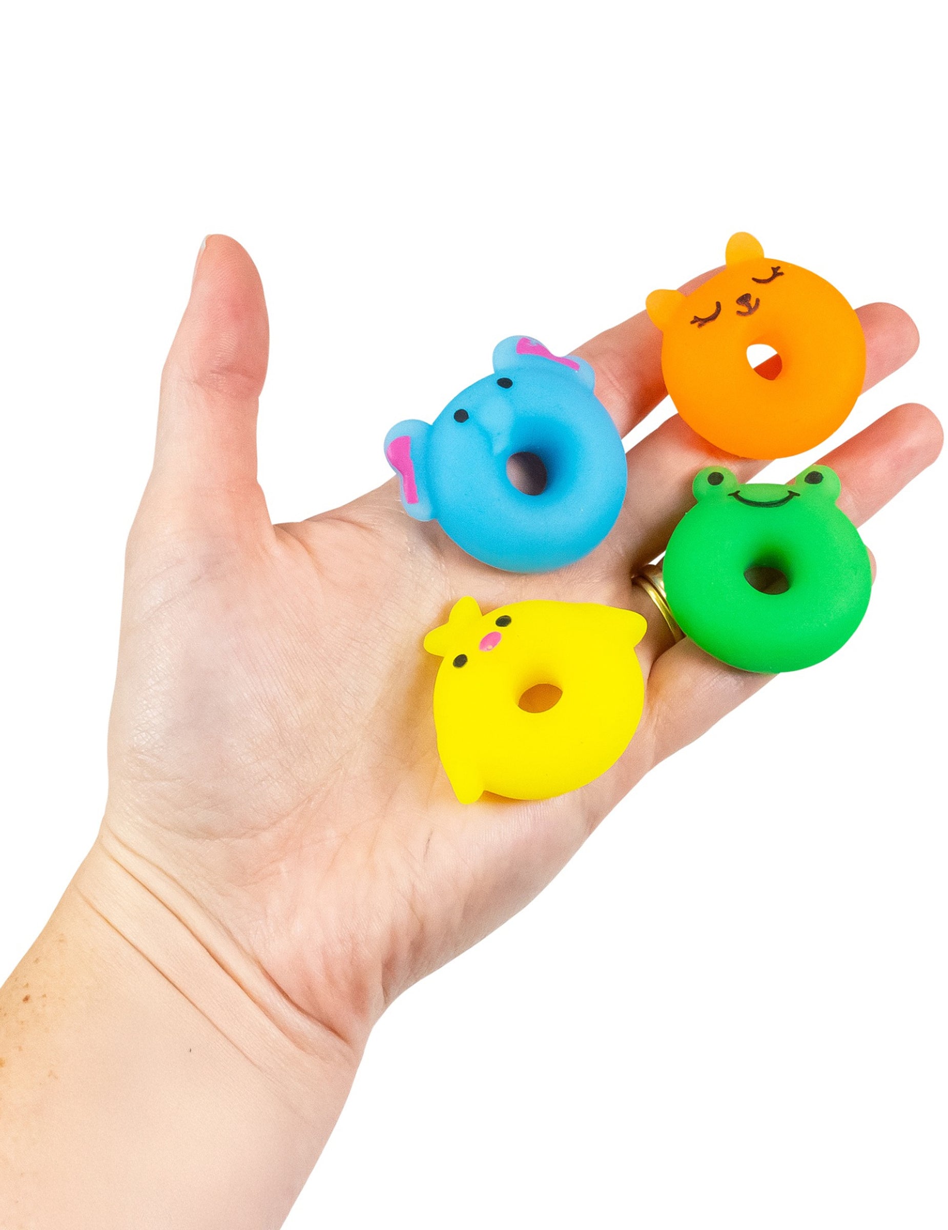 Détail de la taille dans la main du jouet mini animal squishy multicolore en forme de donut