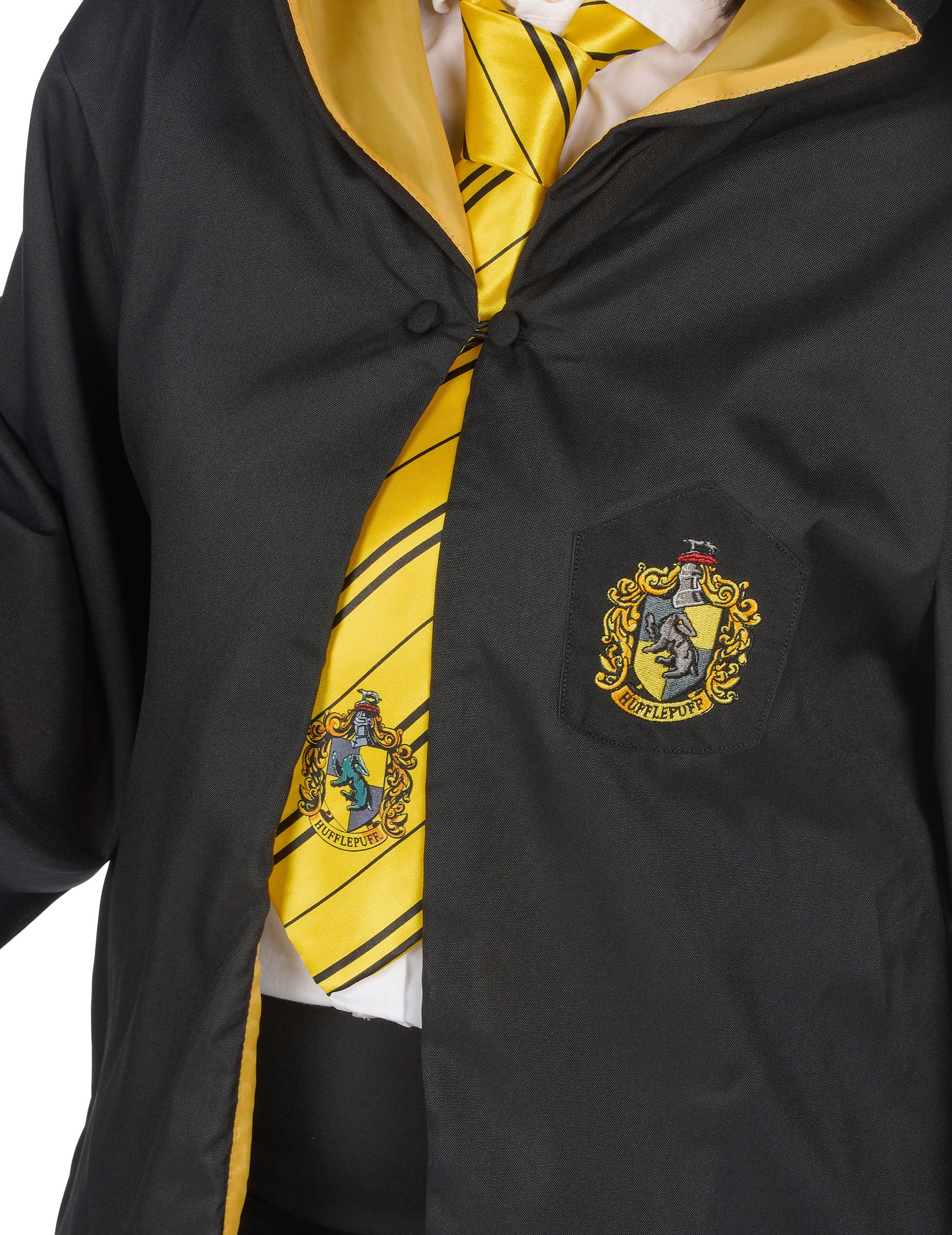 Gros plan sur l'écusson et la cravate jaune de la Réplique luxe robe de sorcier Poufsouffle