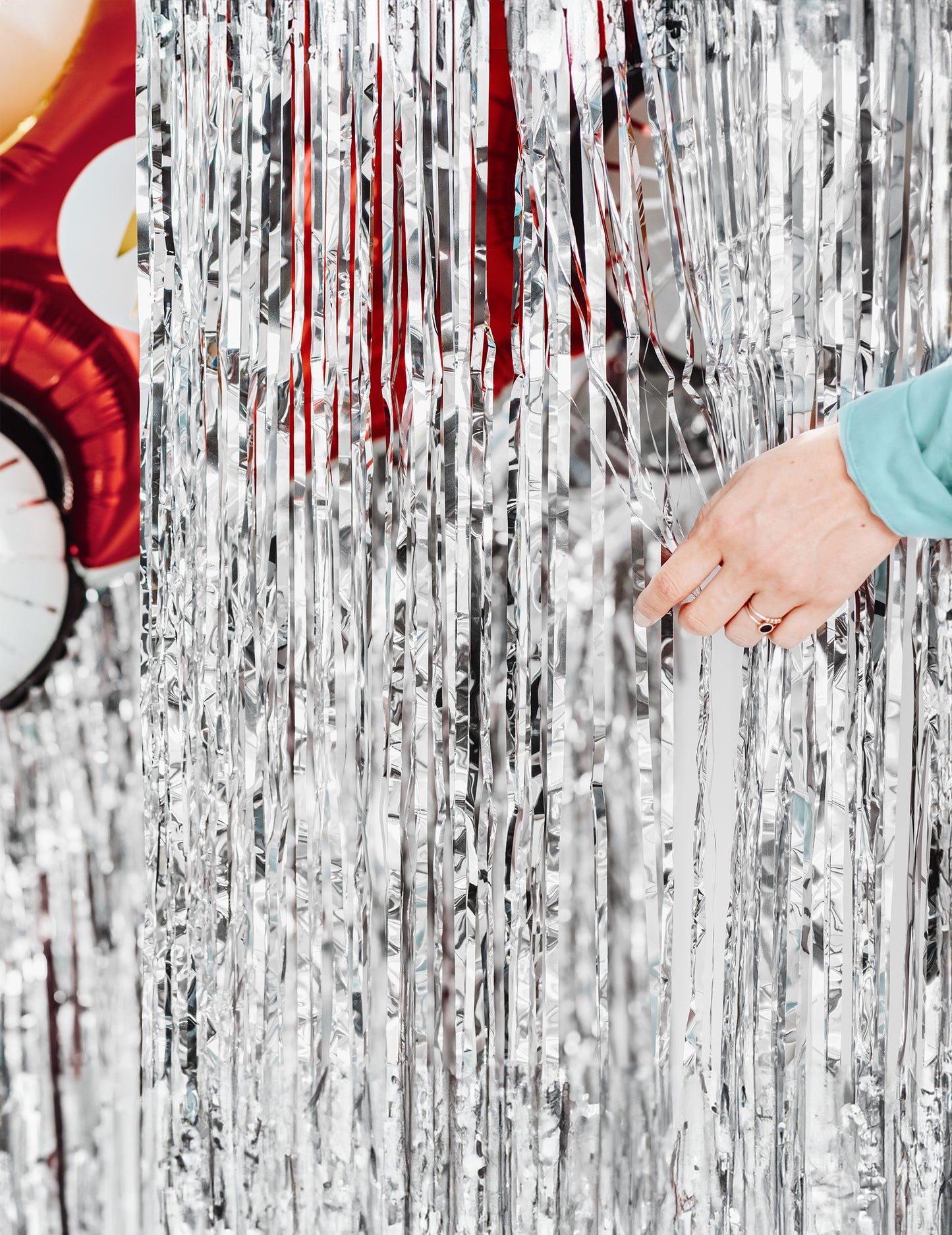 Kéz, amely az ezüst fiesztához készült fénylő függöny fröcsköléseit eltávolítja