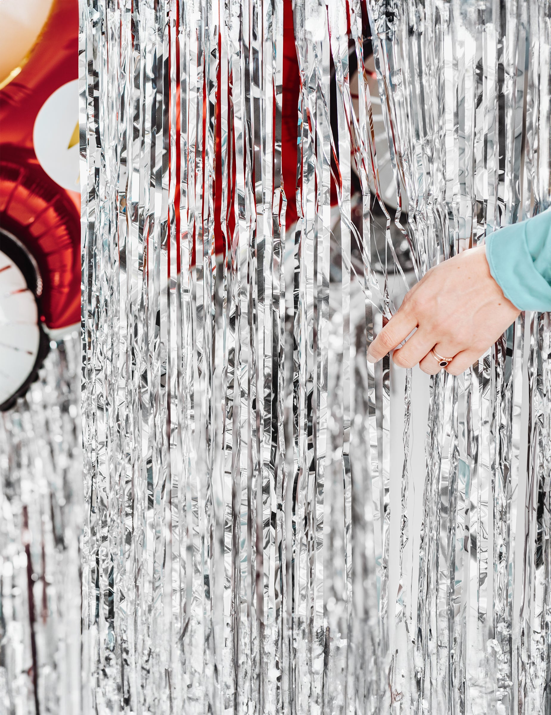 Kéz, amely az ezüst fiesztához készült fénylő függöny fröcsköléseit eltávolítja