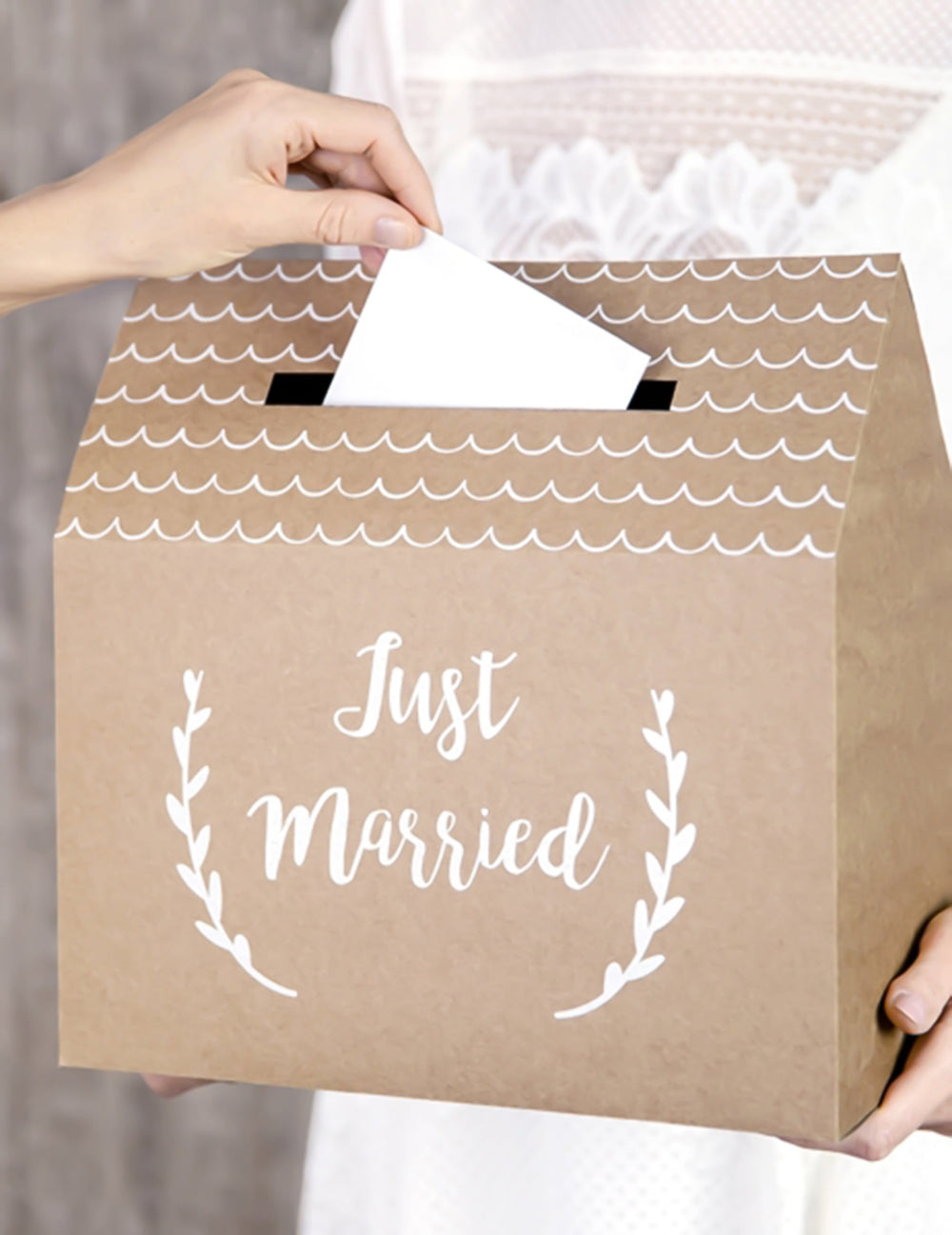 Insertion d'une enveloppe dans l'urne Just Married pour mariage en carton kraft en forme de maison