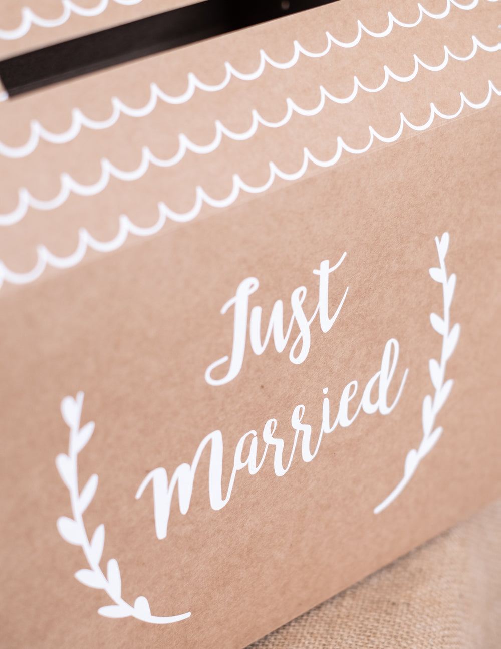 Gros plan sur l'inscription de l'urne Just Married pour mariage en carton kraft en forme de maison